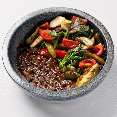 Steak salad with grilled vegetables in a stone bowl