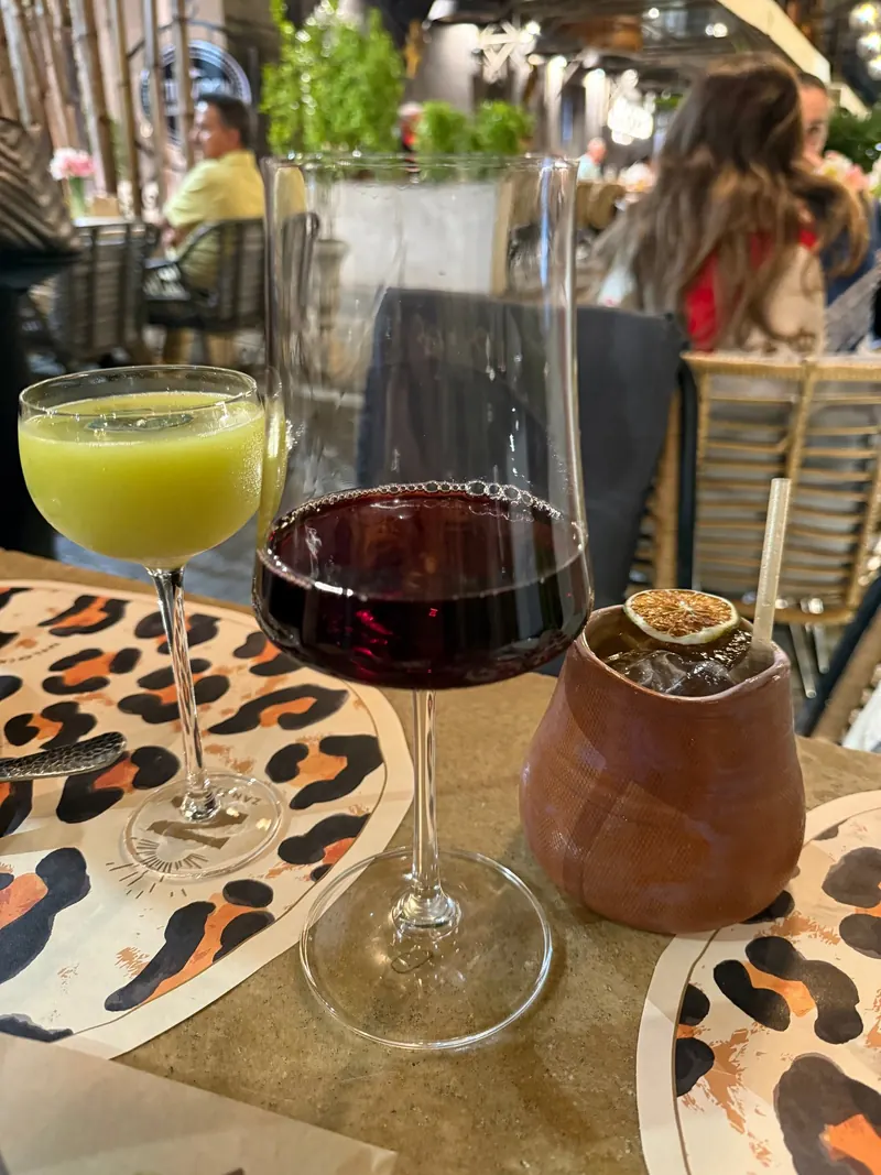 Cocktails and red wine on a leopard-print placemat